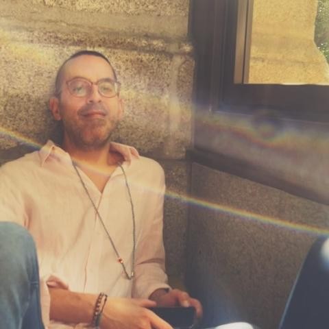 Photo of Edwin Rivera-Arias sitting on the ground with light streaming in